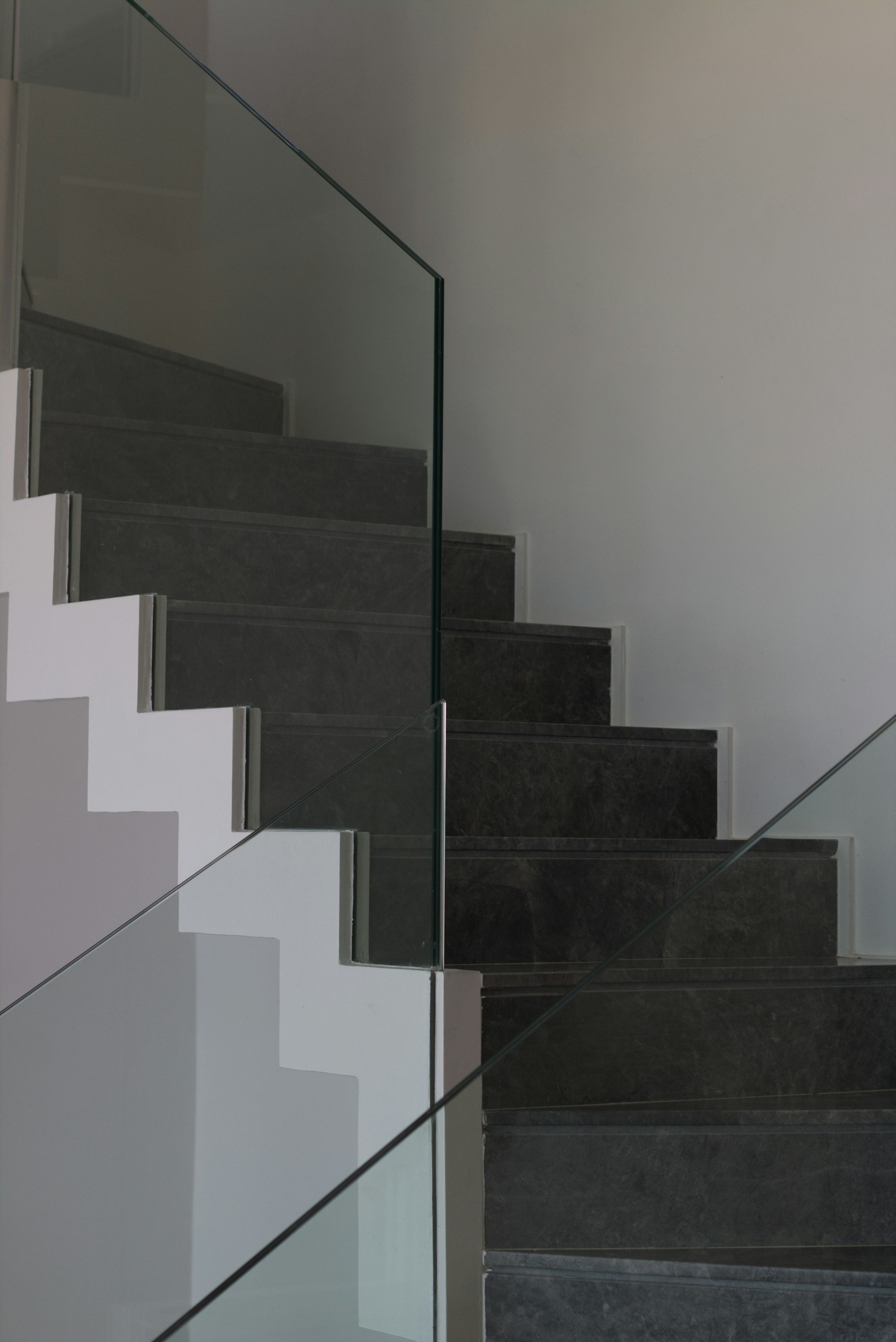 Modern glass railing beside a stone staircase