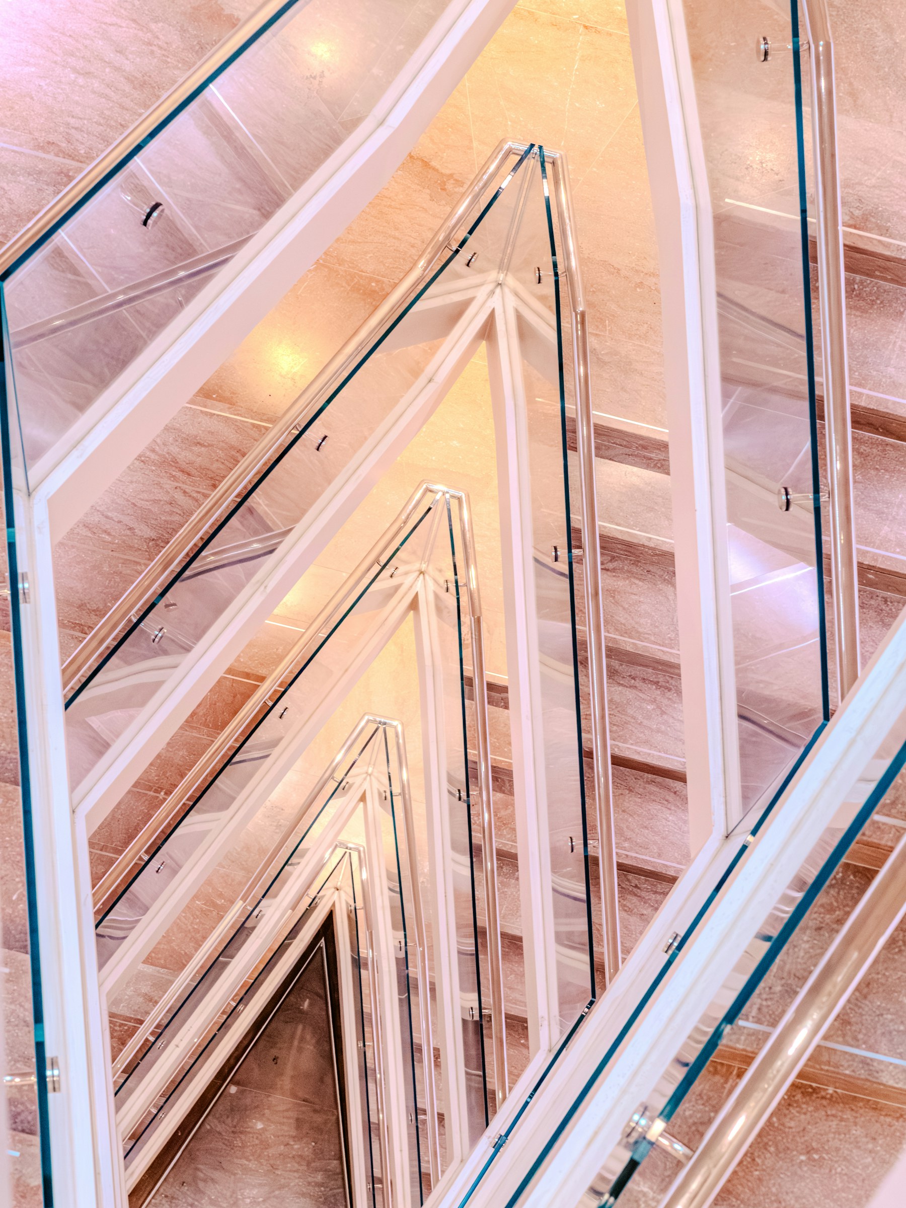 Modern staircase with clear glass railing and geometric light